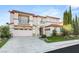 Elegant two-story home featuring a tile roof, manicured landscaping, and a spacious three-car garage, set against a blue sky at 2736 Botticelli Dr, Henderson, NV 89052