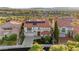 Elegant home with a red tile roof and solar panels, surrounded by lush landscaping and mature trees at 2736 Botticelli Dr, Henderson, NV 89052