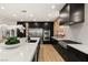 Modern kitchen with stainless steel appliances, black cabinets, a large island with white countertops, and light wood flooring at 2736 Botticelli Dr, Henderson, NV 89052