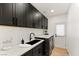 The laundry room features black cabinets, sleek countertops, and modern appliances at 2736 Botticelli Dr, Henderson, NV 89052