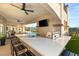 Contemporary outdoor kitchen featuring a bar with seating, a built-in sink, a grill, and a wall-mounted television at 2736 Botticelli Dr, Henderson, NV 89052