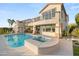 Luxurious backyard with a large swimming pool, a hot tub, lush greenery, and a beautifully designed home at 2736 Botticelli Dr, Henderson, NV 89052