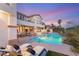 Inviting backyard pool and patio at dusk with luxurious lounge chairs and covered seating areas at 2736 Botticelli Dr, Henderson, NV 89052