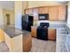 Kitchen with granite countertops, tile flooring, black appliances, and a convenient breakfast bar at 3125 Prairie Princess Ave, North Las Vegas, NV 89081