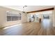 Bright and open living room featuring wood-look tile floors, a kitchen view, and a large window at 356 Gulfport Ct, Las Vegas, NV 89145