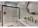 Modern bathroom featuring a glass shower and white vanity with gold fixtures and round mirror at 365 Crown Mesa Ave, Las Vegas, NV 89138