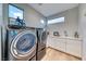 Well-lit laundry room with stainless steel washer and dryer and white cabinets at 365 Crown Mesa Ave, Las Vegas, NV 89138