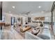 Bright open-concept living room featuring hardwood floors, a large sectional couch, and seamless access to the modern kitchen at 365 Crown Mesa Ave, Las Vegas, NV 89138