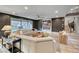Spacious living room boasts a large sectional sofa, a fireplace, and seamless access to the backyard and staircase at 365 Crown Mesa Ave, Las Vegas, NV 89138