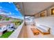 Spacious patio featuring a seating area, hanging chair, and views of the green backyard, playhouse, and hillside at 365 Crown Mesa Ave, Las Vegas, NV 89138