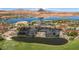 An aerial view of houses and community pond surrounded by a green golf course and desert landscape at 38 Grand Miramar Dr, Henderson, NV 89011
