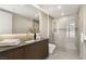 Sleek bathroom featuring a large vanity, glass shower, and neutral stone tile at 4 Horseshoe Rock Ct, Henderson, NV 89012