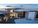A modern home's unique exterior features a circular design element, contrasting textures, and manicured landscape, creating curb appeal at 4 Horseshoe Rock Ct, Henderson, NV 89012