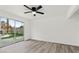 Bright bedroom features modern ceiling fan, wood-look floors, and sliding glass door to the backyard at 4046 Bridgeview Cir, Las Vegas, NV 89147