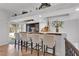 Stylish home bar featuring seating, recessed lighting, white brick accents, and convenient access to the outdoor patio at 4108 Royal Scots Ave, Las Vegas, NV 89141