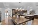 Open dining area showcasing a long dining table, island with seating, and modern chandelier at 4108 Royal Scots Ave, Las Vegas, NV 89141