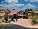Aerial view of a beautiful two-story home with a tile roof, mature trees, and a brick driveway at 4108 Royal Scots Ave, Las Vegas, NV 89141