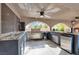 Gourmet outdoor kitchen boasting stainless steel appliances, granite counters, and ceiling fans at 4108 Royal Scots Ave, Las Vegas, NV 89141