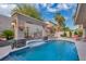 Stunning pool with waterfall feature, lush plants, exterior lighting, and elegant lion's head details at 4108 Royal Scots Ave, Las Vegas, NV 89141