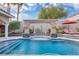 Inviting backyard pool with a stunning water feature, lush landscaping, and relaxation spaces at 4108 Royal Scots Ave, Las Vegas, NV 89141