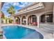 Luxurious backyard pool with covered patio, fireplace, lounge seating, and well-manicured landscaping at 4108 Royal Scots Ave, Las Vegas, NV 89141