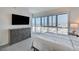 Bedroom with expansive windows showcasing city views, a TV, dresser and modern decor at 4525 Dean Martin Dr # 1208, Las Vegas, NV 89103