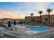 Community pool with palm trees, lounge chairs, umbrellas, and stunning sunset views at 4575 Dean Martin Dr # 304, Las Vegas, NV 89103