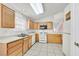Well-lit kitchen with tile floors, white appliances, and wood cabinets provides ample storage space at 5429 Sweet Shade St, Las Vegas, NV 89130