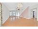 Spacious living room with stylish chandelier, ceiling fan, light wood floors, and large windows at 5429 Sweet Shade St, Las Vegas, NV 89130