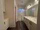 Modern bathroom with double sinks, white cabinets, dark floors, and a shower at 5591 La Perla Ct, Las Vegas, NV 89122