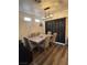 Dining room with a modern chandelier, seating for six and luxury vinyl floors at 5591 La Perla Ct, Las Vegas, NV 89122