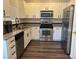 Modern kitchen with stainless steel appliances, granite countertops, and white cabinets at 5591 La Perla Ct, Las Vegas, NV 89122