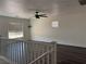 Upstairs room featuring dark floors, neutral paint, large windows and a ceiling fan at 5591 La Perla Ct, Las Vegas, NV 89122