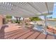 Outdoor patio with a white pergola, offering a shaded retreat with a view of the landscaped backyard and gazebo at 5829 W Patrick Ln, Las Vegas, NV 89118