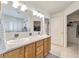 This bathroom features a dual sink vanity, framed mirror, and a walk-in closet at 5829 W Patrick Ln, Las Vegas, NV 89118