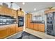 Spacious kitchen with modern appliances, wooden cabinets, dark countertops, and tile backsplash for easy cleaning at 5829 W Patrick Ln, Las Vegas, NV 89118