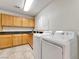 Functional laundry room with ample cabinet space, countertops, utility sink, and modern washer and dryer at 5829 W Patrick Ln, Las Vegas, NV 89118