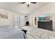 The main bedroom showcases a ceiling fan, dresser with TV, and sliding glass doors to the outside at 5829 W Patrick Ln, Las Vegas, NV 89118