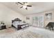 This spacious main bedroom features a ceiling fan, sliding glass doors, and neutral carpeting at 5829 W Patrick Ln, Las Vegas, NV 89118
