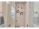Walk-in shower boasts tiled walls, mosaic tile flooring, and recessed shelving for bath products at 5829 W Patrick Ln, Las Vegas, NV 89118
