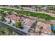 Aerial view of a beautiful home with a tile roof and a lush green golf course in the background at 62 Incline Village Ct, Henderson, NV 89074