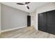 Bedroom features stylish wood-style floors, ceiling fan, closet with black double doors, and neutral paint at 62 Incline Village Ct, Henderson, NV 89074