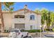 Exterior view of a condo building featuring assigned parking, desert landscaping, and a stucco facade at 6480 Annie Oakley Dr # 624, Las Vegas, NV 89120
