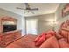 Spacious bedroom featuring a decorative bed with red pillows, dresser, TV, ceiling fan, and natural light at 6480 Annie Oakley Dr # 624, Las Vegas, NV 89120