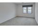 Bedroom with a large window and neutral carpet at 681 Stone Hammer Ave, Las Vegas, NV 89183