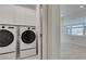 Convenient laundry room with modern washer and dryer units and built-in white cabinets at 681 Stone Hammer Ave, Las Vegas, NV 89183