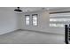 Spacious living room with large windows, modern ceiling fan, and neutral carpet at 681 Stone Hammer Ave, Las Vegas, NV 89183