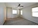 Carpeted bedroom featuring neutral walls, three windows, and a ceiling fan at 7089 Oberling Bay Ave, Las Vegas, NV 89113