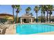 A community pool with a covered area and palm trees, perfect for relaxation at 7089 Oberling Bay Ave, Las Vegas, NV 89113
