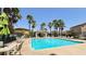 Community pool featuring a covered seating area, lounge chairs, and palm trees at 7089 Oberling Bay Ave, Las Vegas, NV 89113